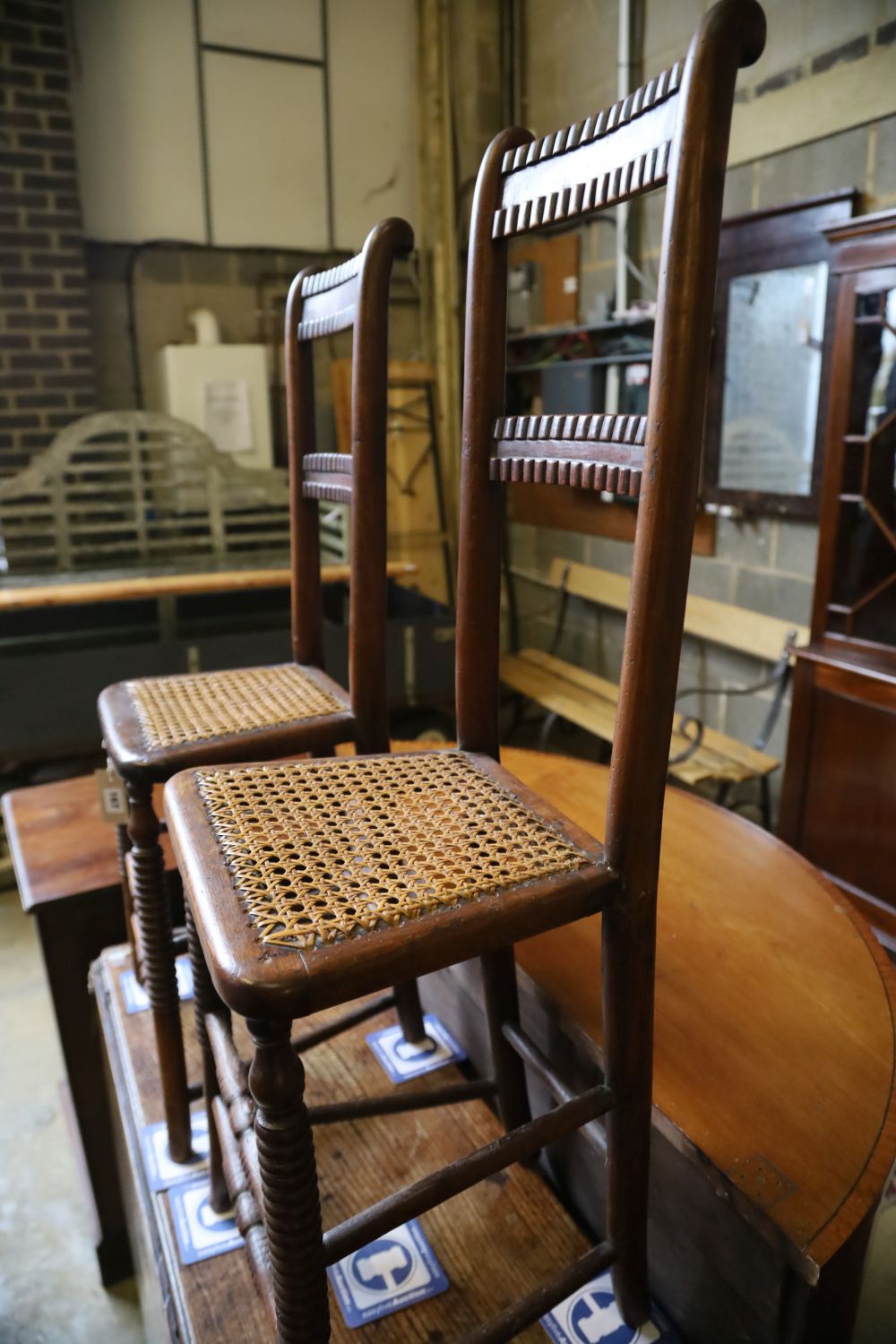 A pair of Regency provincial cane seat correction chairs (one cut down)